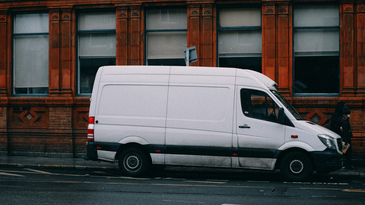 A plain white removals van parked on a city street
